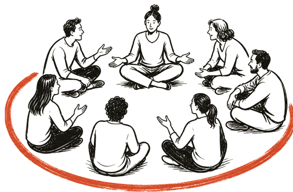 A circle of people sitting on the floor in conversation